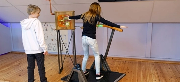 Två barn som står på en balansbräda.