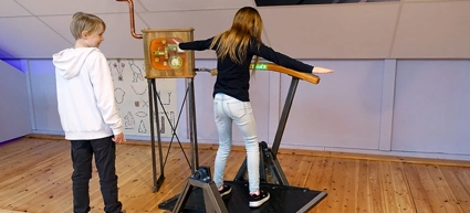Två barn som står på en balansbräda.