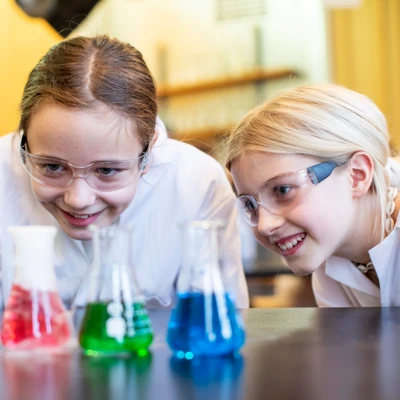 två barn med labbrockar