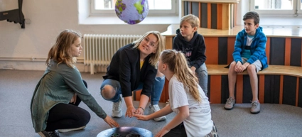 En vuxen och fyra barn provar experimentet Blåshålet