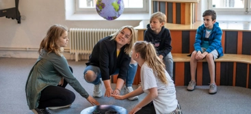 En vuxen och fyra barn provar experimentet Blåshålet
