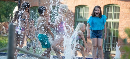 A group of children playing in a water fountain.