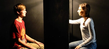 A man and a woman sitting on a chair facing each other.