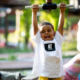 A young boy holding a barbell above his head.