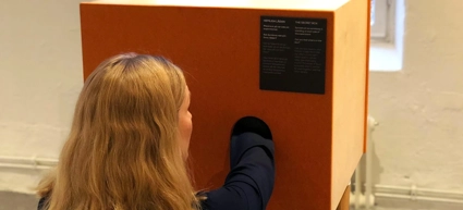 kvinna bakifrån med handen i en låda