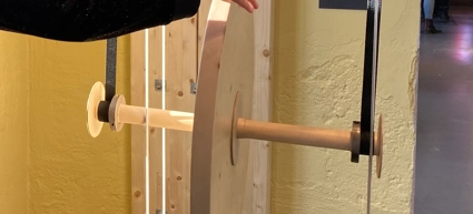En person som håller en träbit framför en dörr.