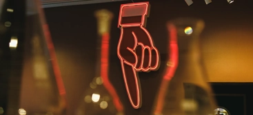 A neon sign that is on the side of a wall.