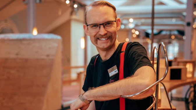 En man sitter på ett träbord.