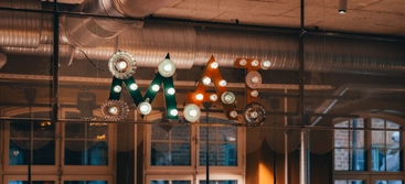 A number of lights hanging from a ceiling and forming the letters mat