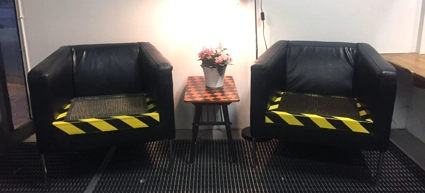 Några svarta stolar som står bredvid varandra. Stolarnas simplast är fylld med nålar.