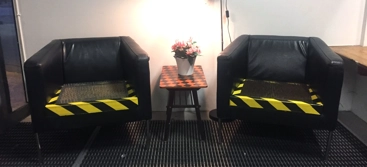 Två svarta fåtöljer med sittdyna av nålar.