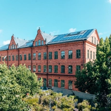 A red brick building surrounded by trees and bushes.