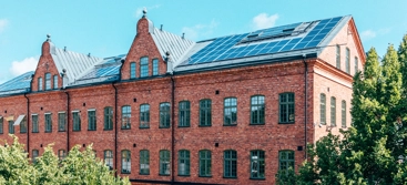 A red brick building surrounded by trees and bushes.