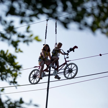 Två barn cyklar på lina