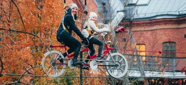 Vuxen och barn cyklar på lina