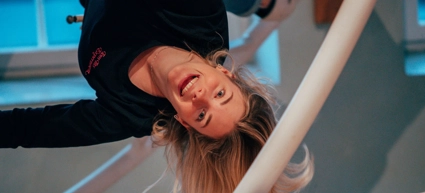 A girl is upside down i the ride space ball
