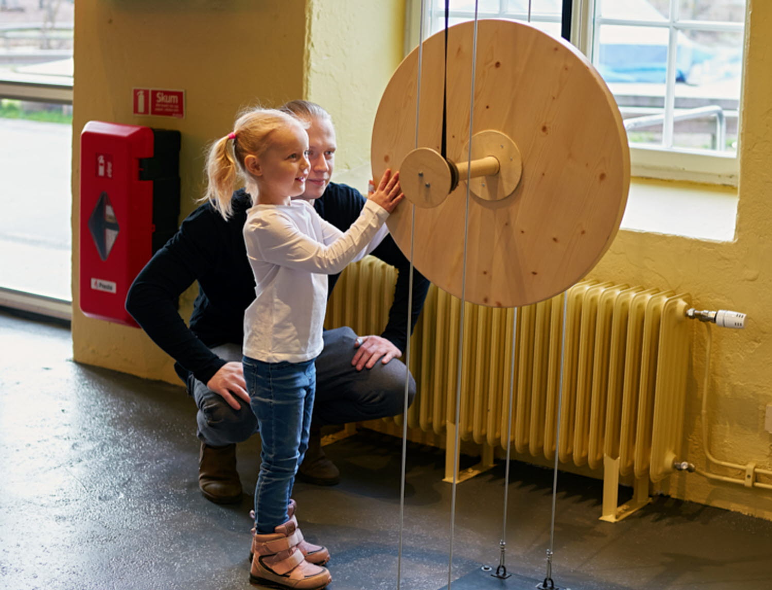 Ett barn och en vuxen provar experimentet Jojo-hjulet