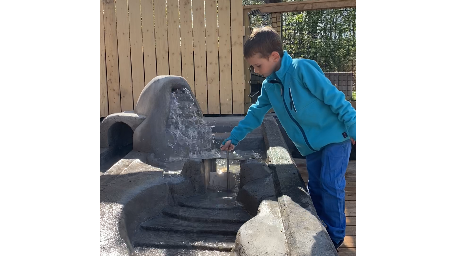 En pojke som öppnar vattenslussen vid Meanderleken
