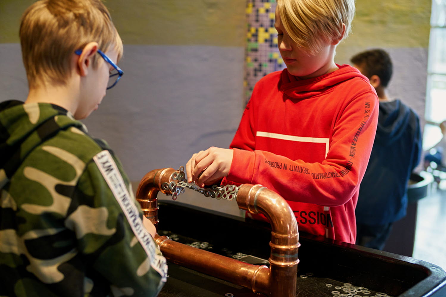 Två barn provar experimentet Magnetbron Två barn provar experimentet Magnetbron