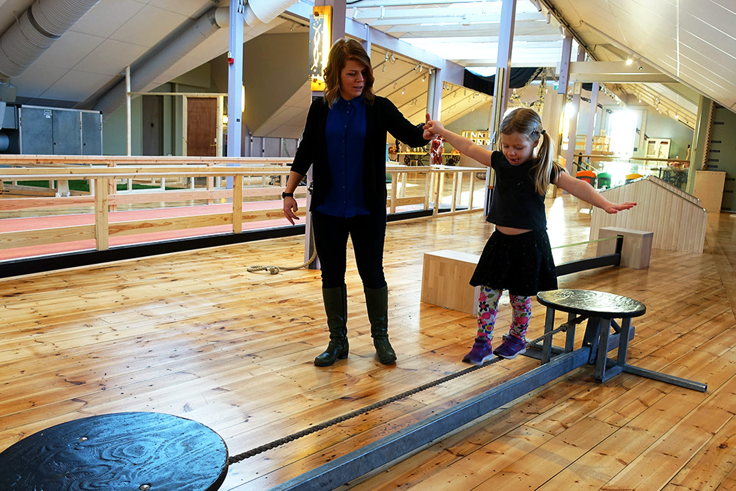 En vuxen och ett barn provar experimentet Gå på lina En vuxen och ett barn provar experimentet Gå på lina