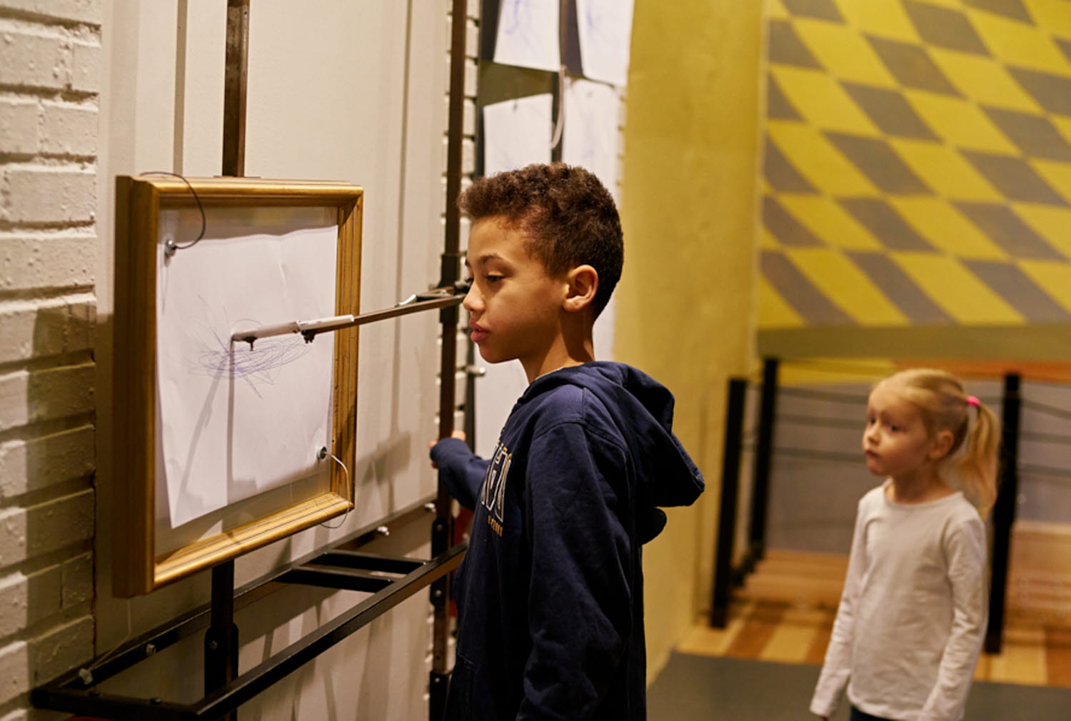Två barn provar experimentet Ritpendlarna