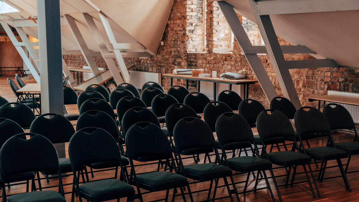 stolar framfor tegelvagg i konferenslokal