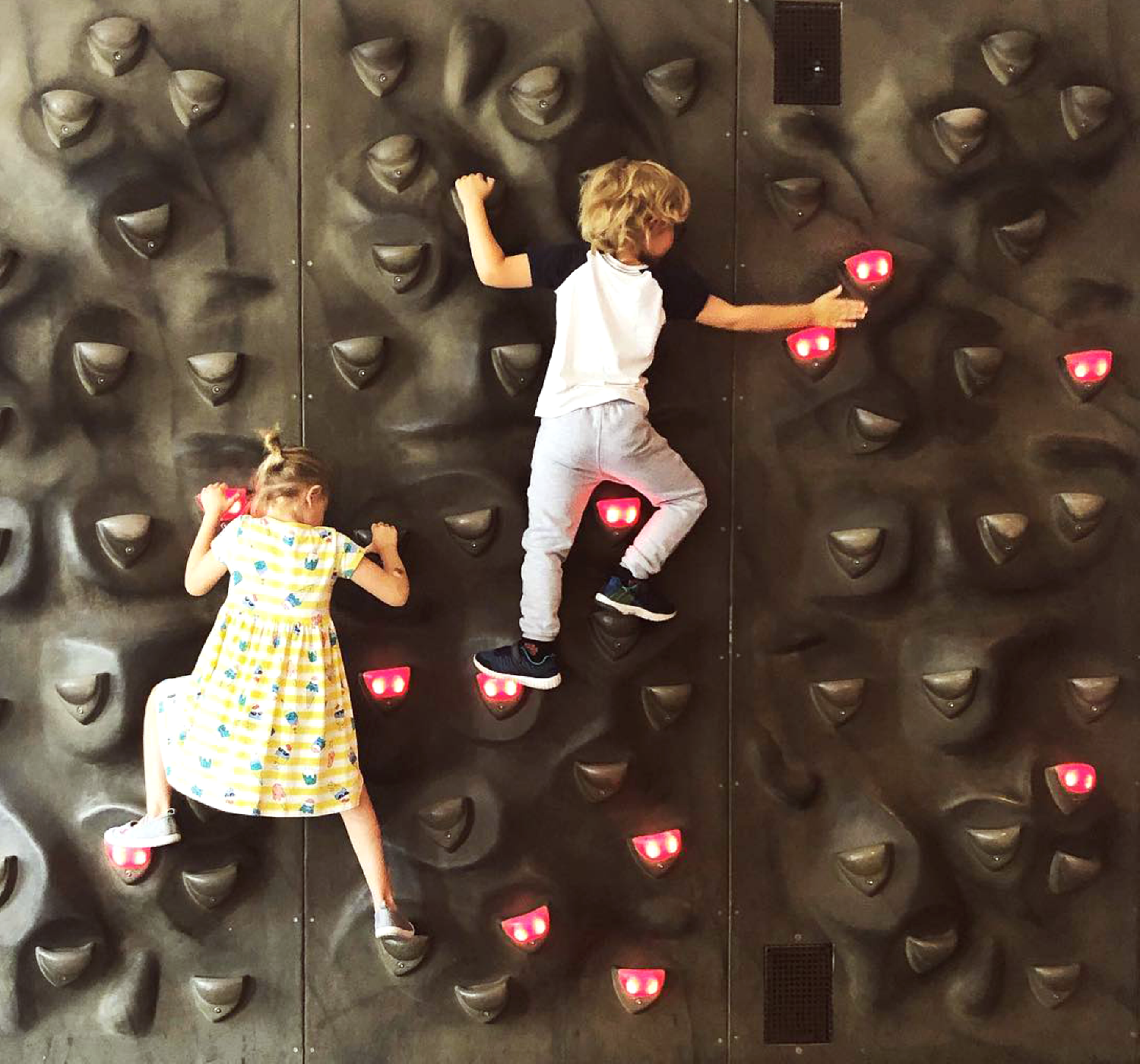 Två barn klättrar på Digi wall
