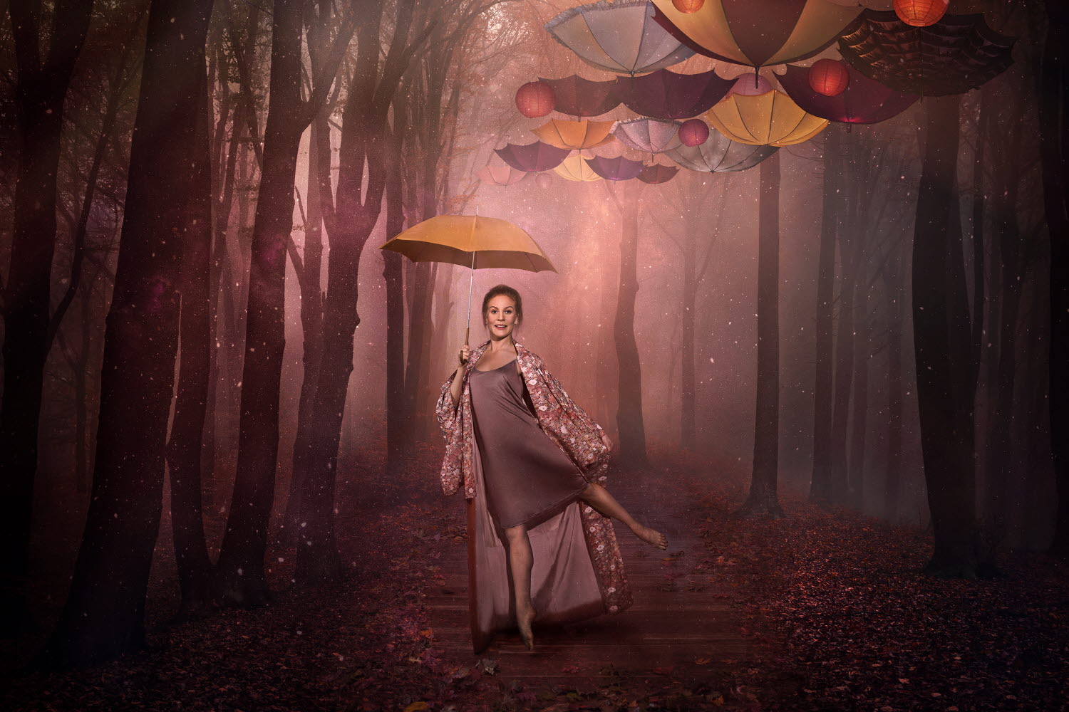 Kvinna står på ett ben och håller ett paraply