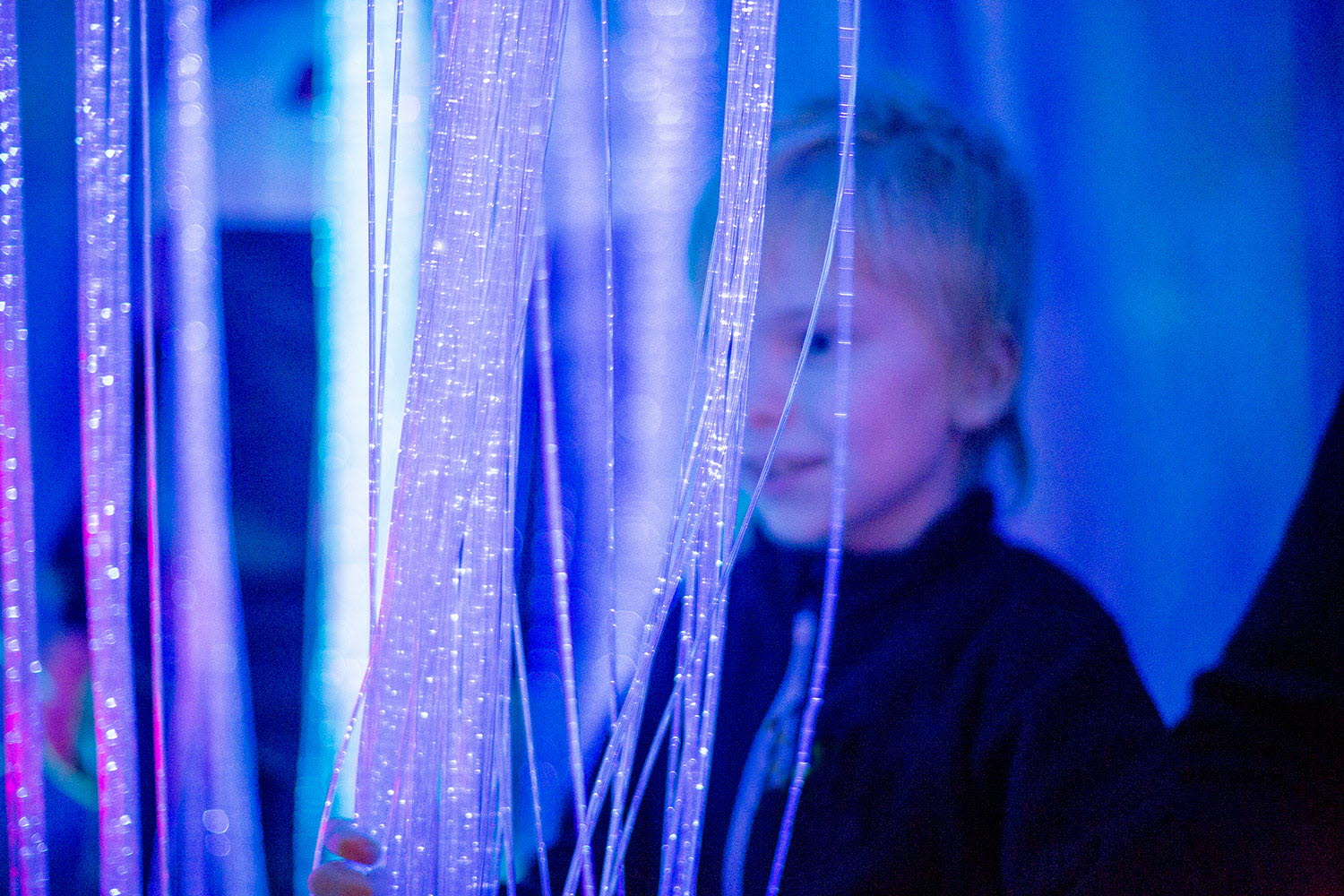 Bild på pojke som tittat på ljusslingor i ett blått rum