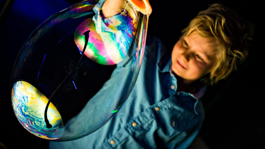 A child is holding a soap bubble