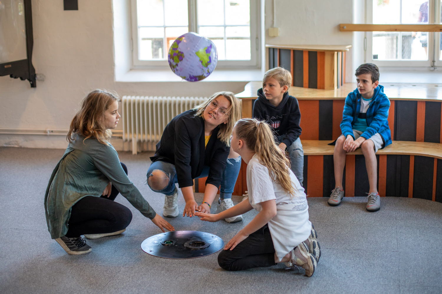 En vuxen och fyra barn provar experimentet Blåshålet En vuxen och fyra barn provar experimentet Blåshålet